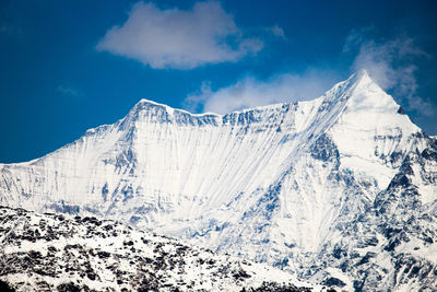 Snow covered mountain against blue sky