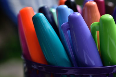 Close-up of colorful pens in container