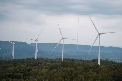 Wind turbines on land against sky