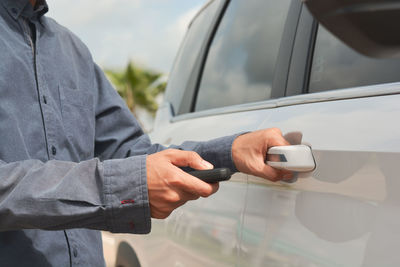 Midsection of man using mobile phone