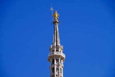 Low angle view of statue at duomo di milano against clear blue sky