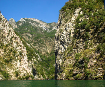 Scenic view of sea and mountains against clear sky