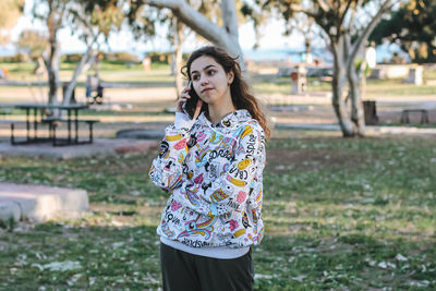 Portrait of young woman standing against plants