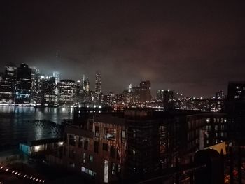 Illuminated cityscape against sky at night