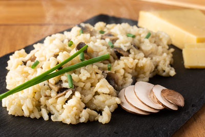 Close-up of rice and mushroom slices on slate