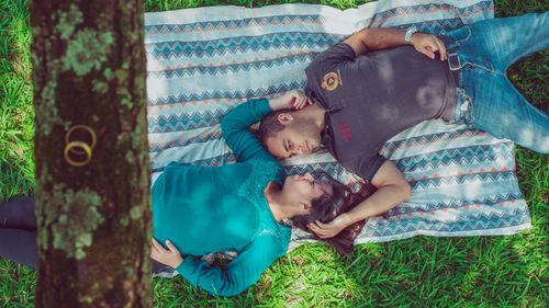 Full length of young woman with dog lying on grass