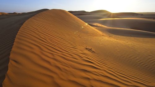 Sand dune in desert against sky