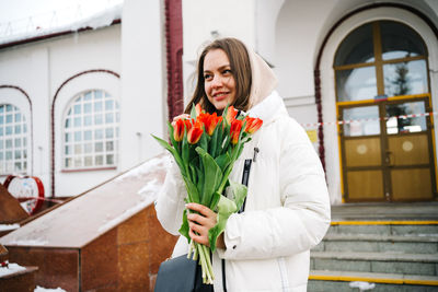 Girl with a bouquet of tulips at the train station, international women's day