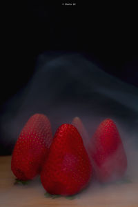 Close-up of strawberries on table against black background