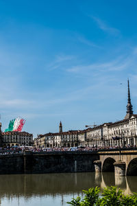 Arch bridge over river against buildings