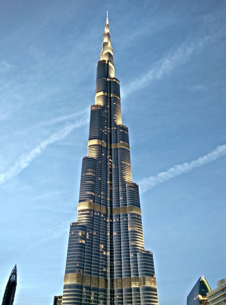 building exterior, architecture, built structure, low angle view, tall - high, tower, sky, blue, city, skyscraper, famous place, cloud - sky, travel destinations, tall, spire, outdoors, international landmark, modern, cloud, day