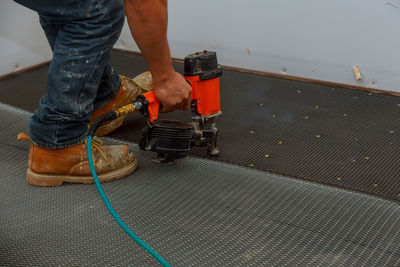 Low section of man working on metal