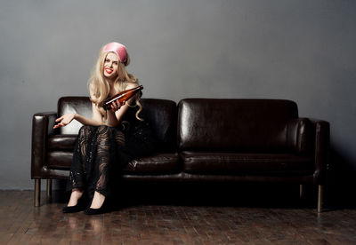 Young woman sitting on sofa at home