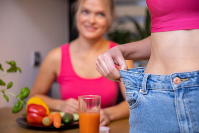 Midsection of woman holding drink at home