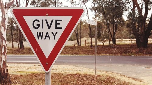 Road sign against trees