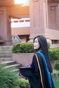 Woman standing by building