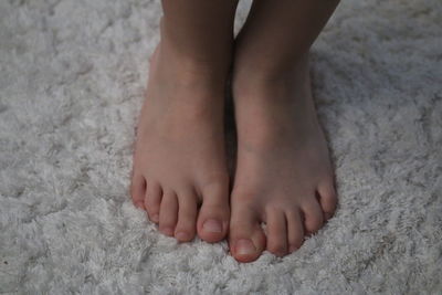 Low section of baby feet on rug