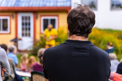 Rear view of man standing against buildings in city