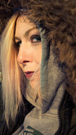 Close-up portrait of young woman wearing fur hood
