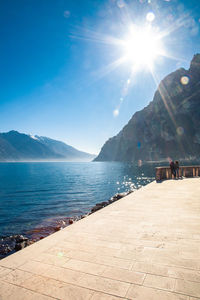 Scenic view of sea against blue sky on sunny day