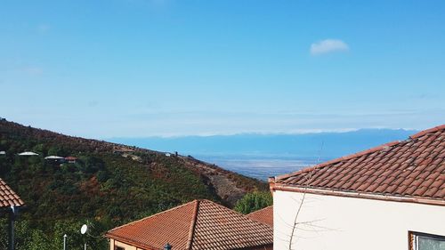 Houses by mountains against sky