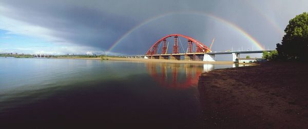 Bridge over river against cloudy sky