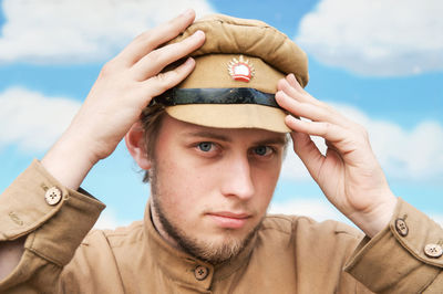 Portrait of young man wearing costume against sky