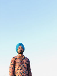 Portrait of a young man against clear sky