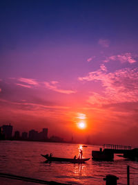 Silhouette boats in sea against sky during sunset