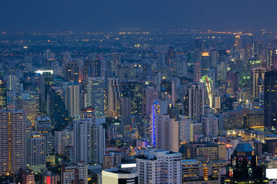 Illuminated cityscape against sky at night