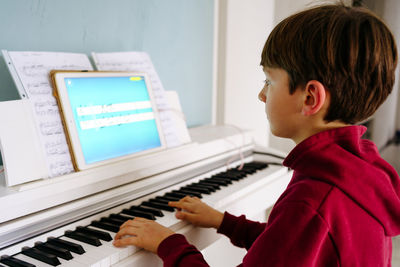Boy playing piano at home