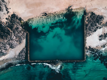 Aerial view of swimming pool by sea against sky