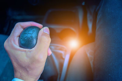 Midsection of man holding gearshift in car