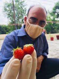 Portrait of man holding strawberries