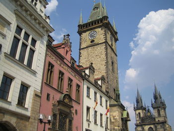 Low angle view of clock tower amidst buildings against sky