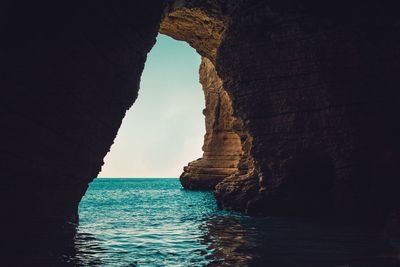 Rock formation in sea against sky