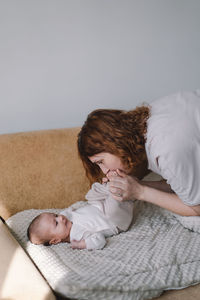 Portrait of happy mum holding infant child on hands.