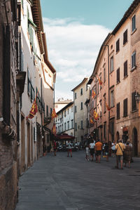 People walking on street amidst buildings in city