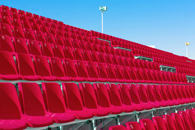 Rows of empty red color plastic stadium seating on the terrace