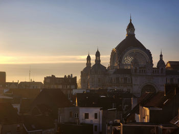 Buildings in city against sky during sunset