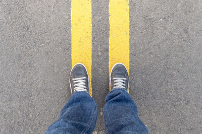 Low section of man standing on road