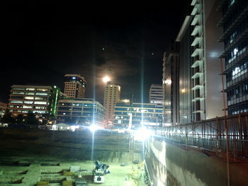 Illuminated cityscape against sky at night