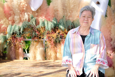 Portrait of smiling woman standing against plants