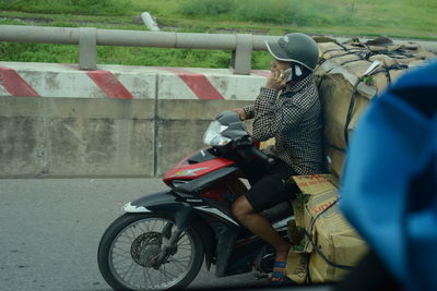 Rear view of people riding motorcycle