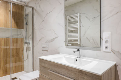 Interior of modern refurbished bathroom with shower with wooden finishing