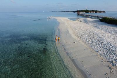 Mother and son walking on a beach of the maldive islands