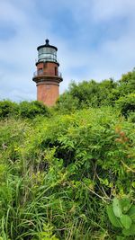 Lighthouse by sea against sky