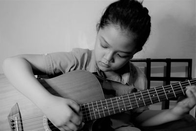 Boy playing guitar at home