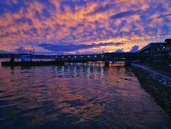 Bridge over river against sky during sunset