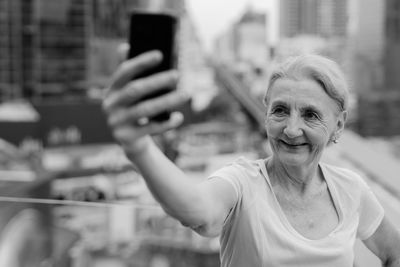 Portrait of smiling young woman using mobile phone